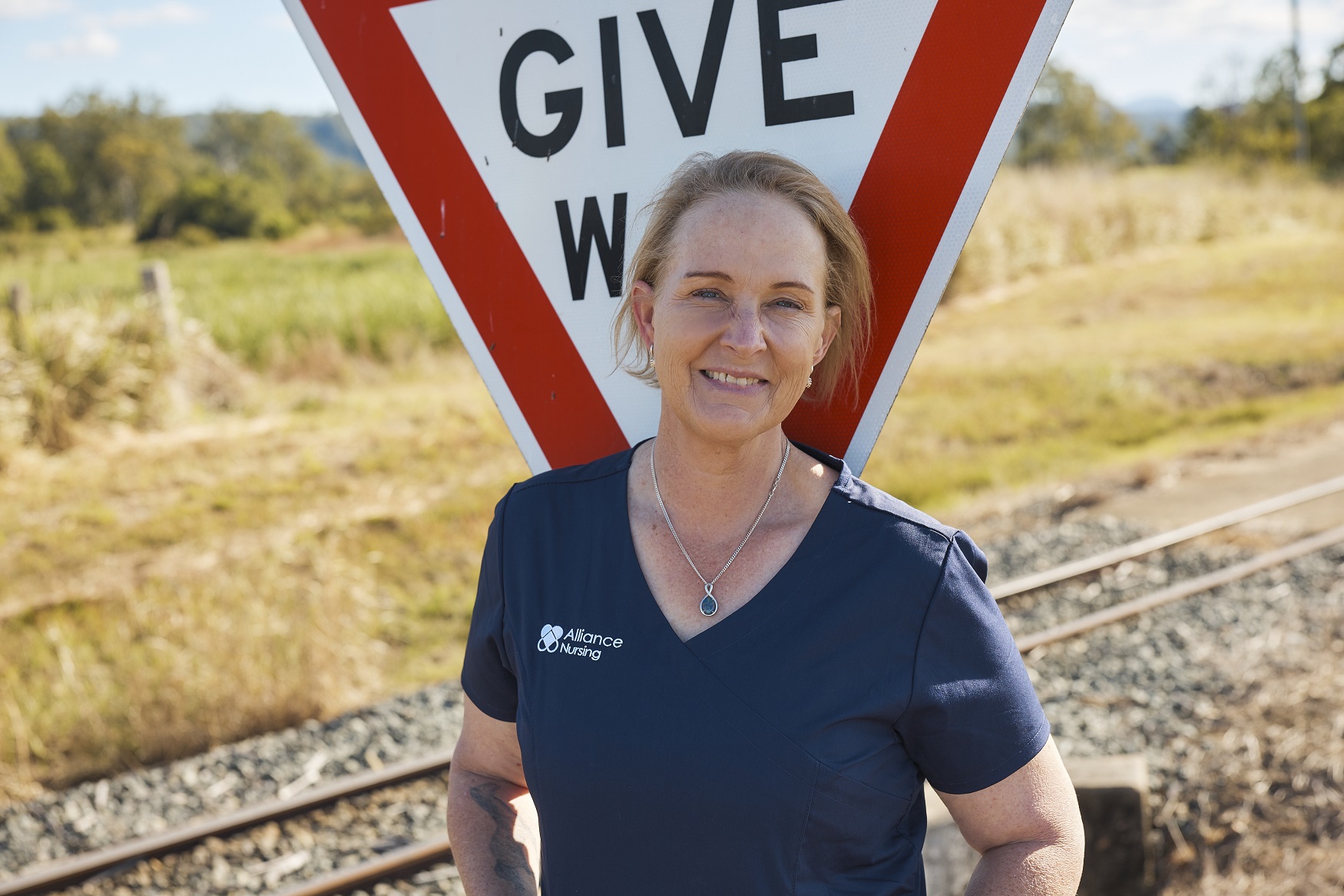 Nurse smiling near give way sign